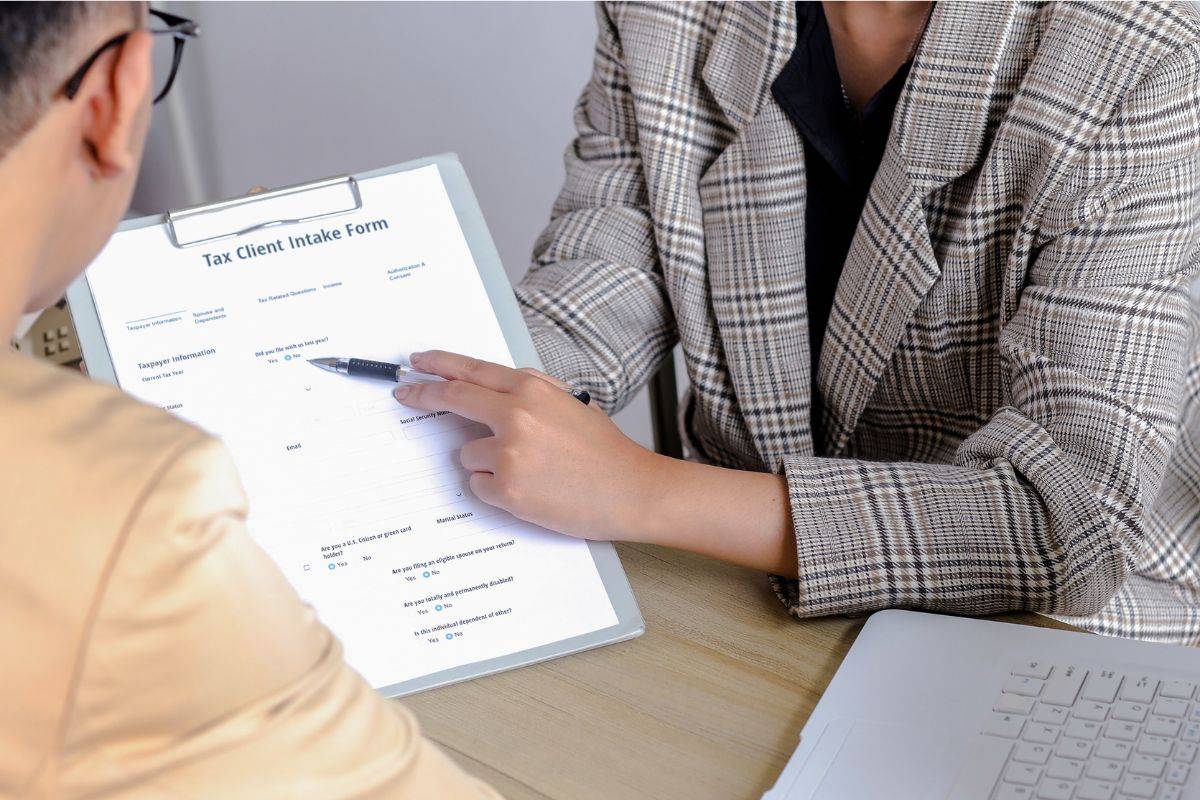 Insurance agent in Sydney explaining policy details to a client, reviewing a claim or application form during a consultation.