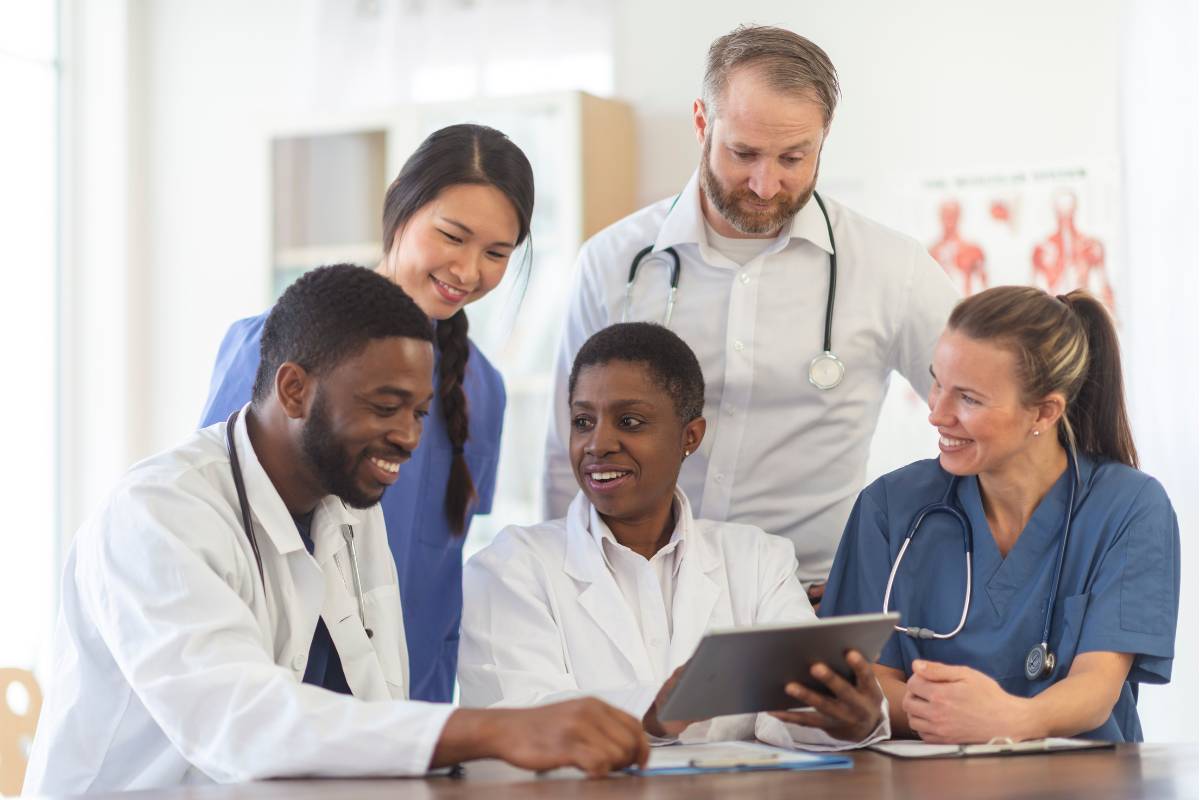 Healthcare professionals in Sydney collaborating on patient care, reviewing medical information together on a digital tablet during a team meeting