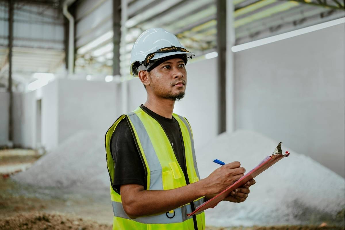 Worker in safety gear inspecting a construction site