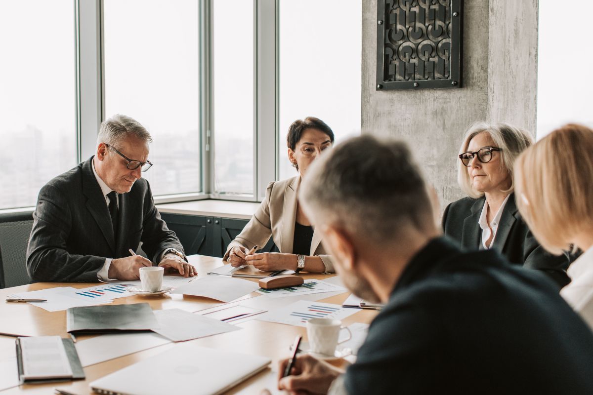 a group of business people sitting around a conference table