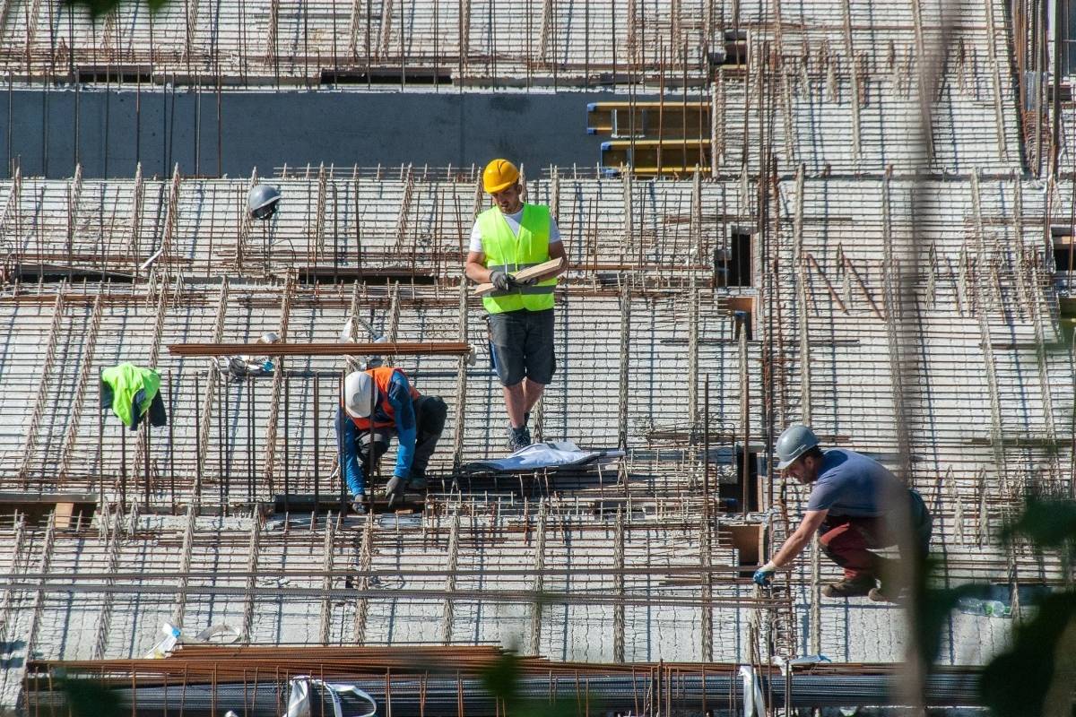 Construction in Sydney with workers installing steel reinforcement on a slab, preparing a commercial build on an active job site.