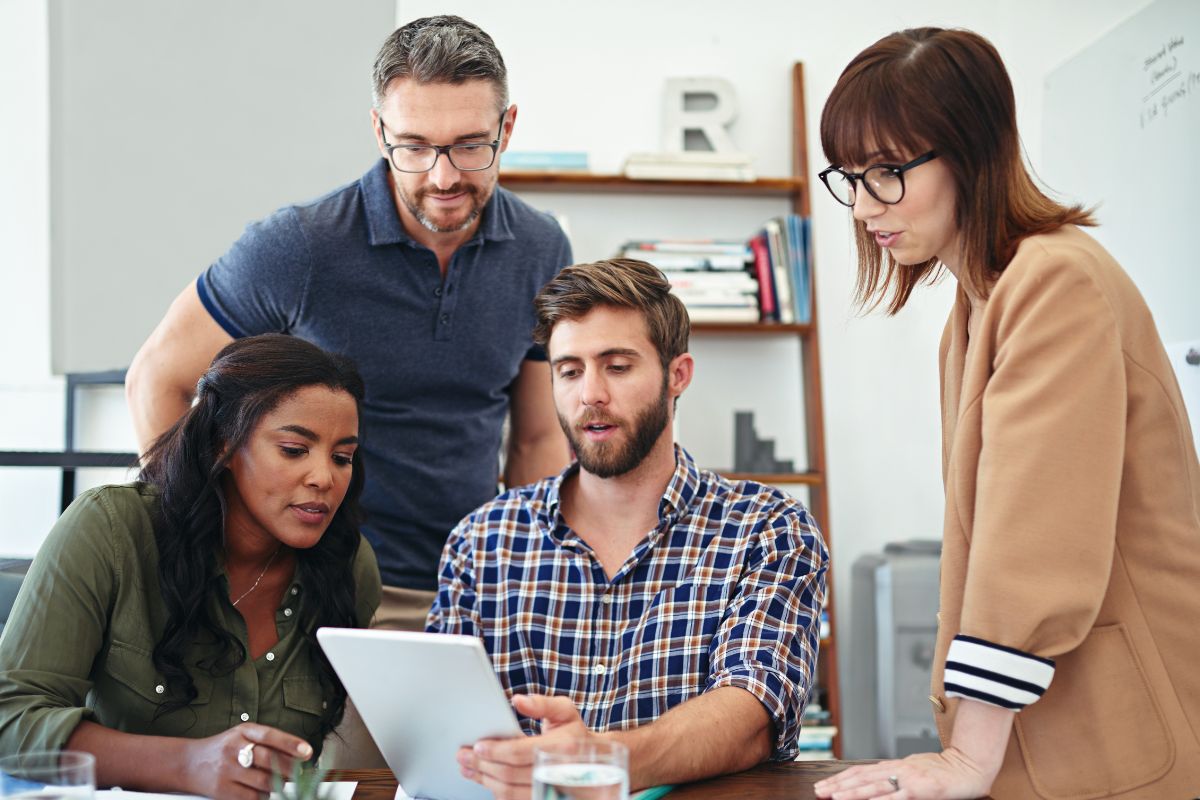a group of people looking at something on a tablet